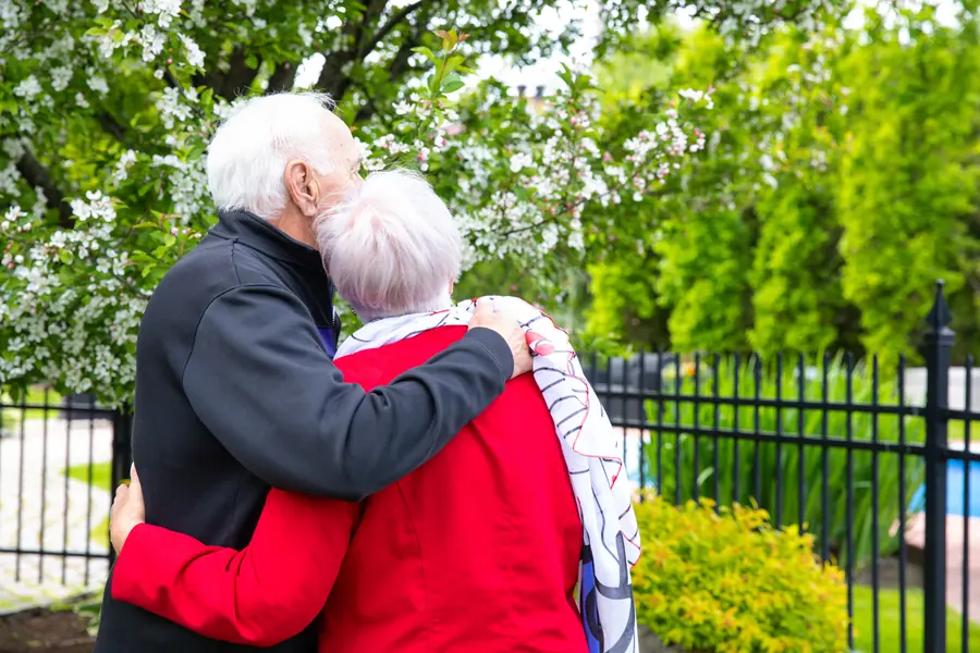Un couple d’aînés partage un moment de tendresse dans un parc
